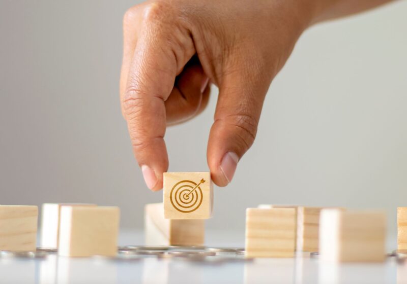 hand holding a block with a target symbol on it